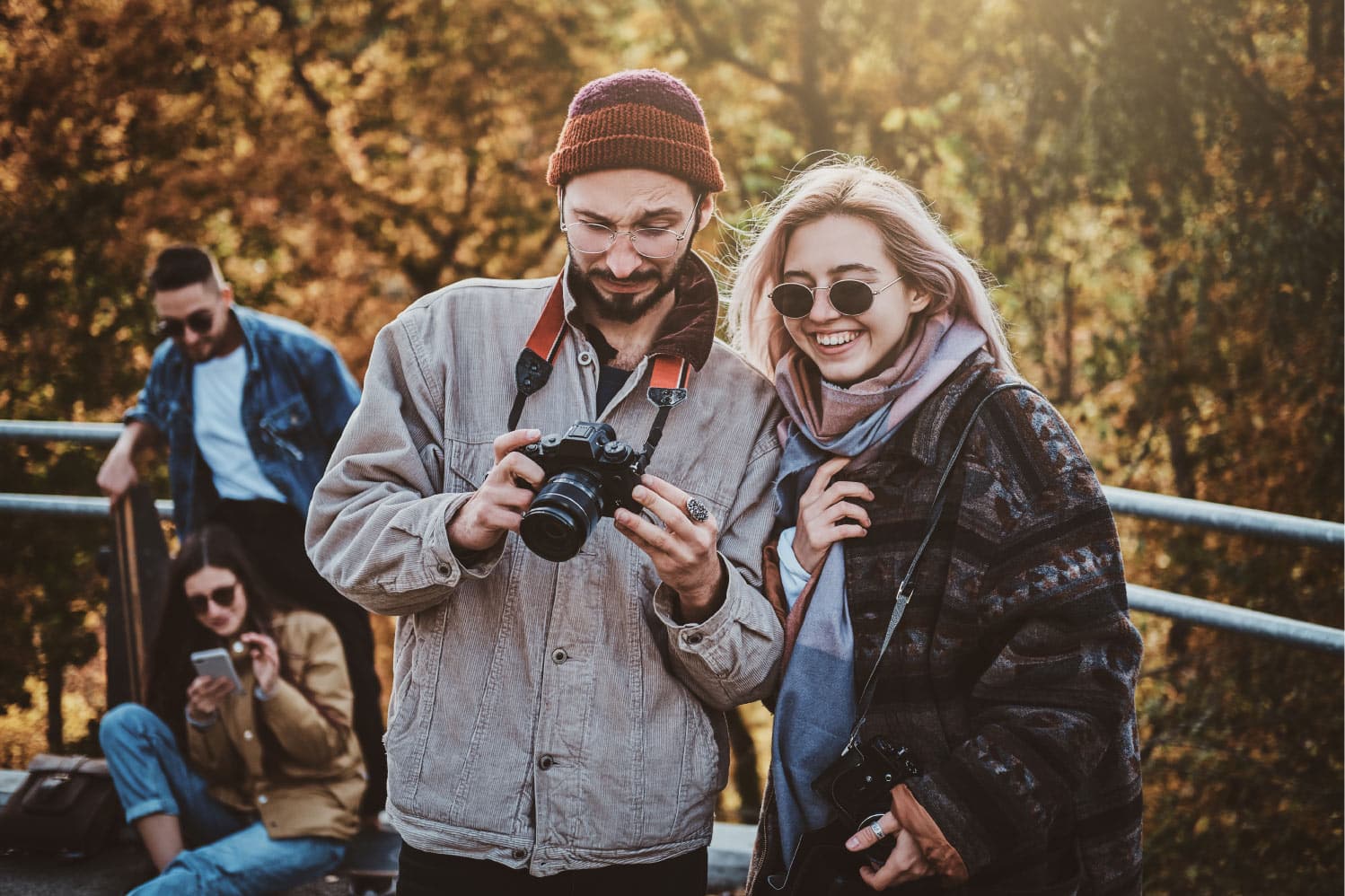 hipster attrayant montre des photos pour sa petite amie souriante au parc d automne